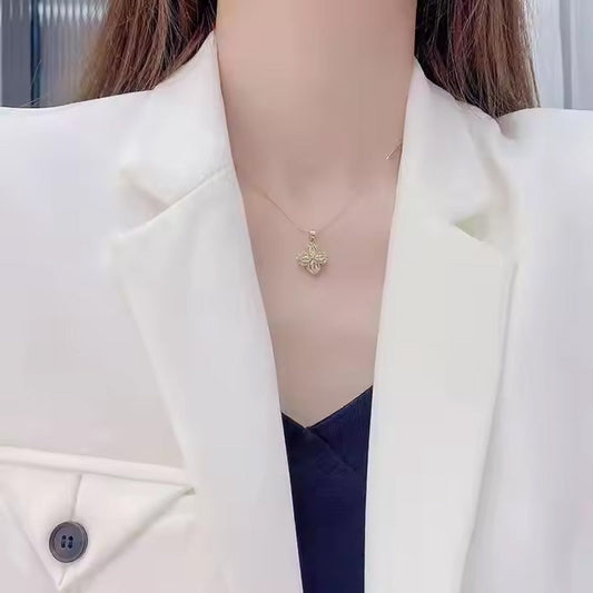 Halsband med roterande blomma och fyrklöver